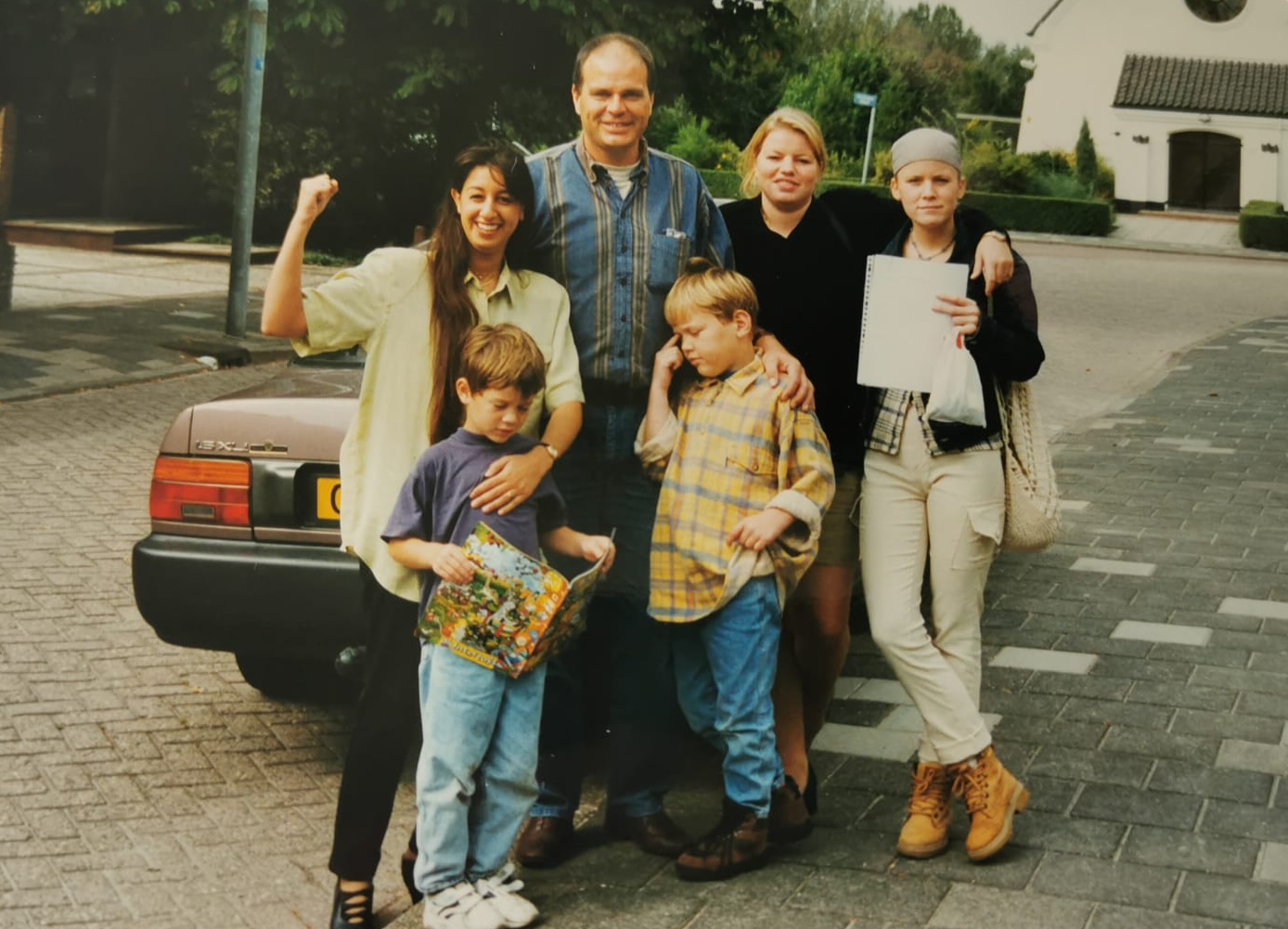 Familieteam poseert bij de auto tijdens de puzzeltocht van 1996